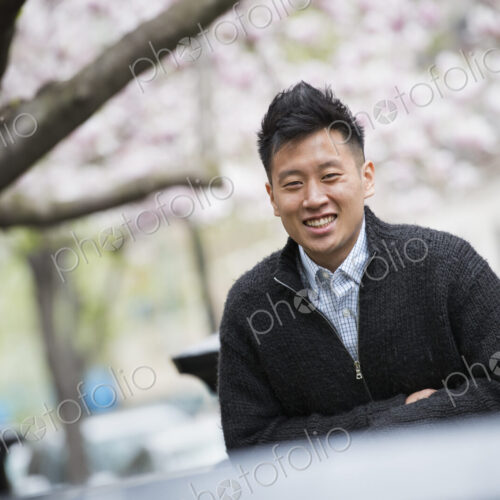 City life in spring. A young man outdoors in a city park. Sitting on a bench. City life in spring. A young man outdoors in a city park. Sitting on a bench.