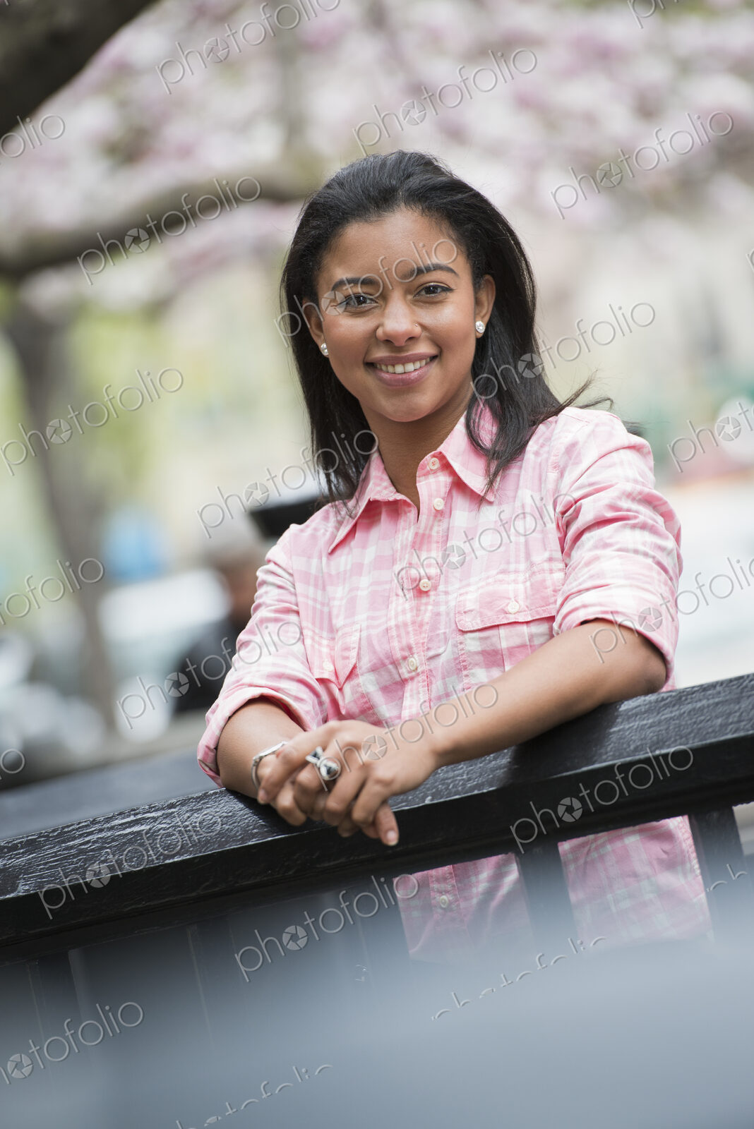 City life in spring. A young woman with black hair, wearing a pink shirt, looking over…