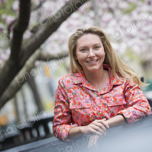 City life in spring. A young woman with long blonde hair, outdoors in a city park.