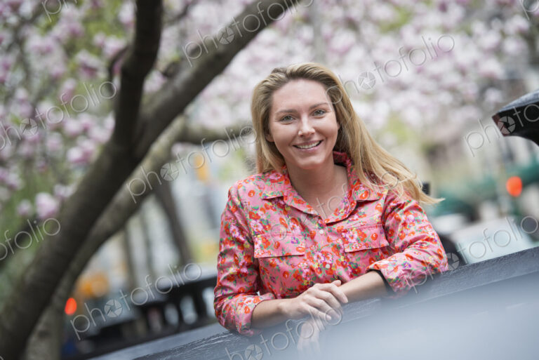 City life in spring. A young woman with long blonde hair, outdoors in a city park.