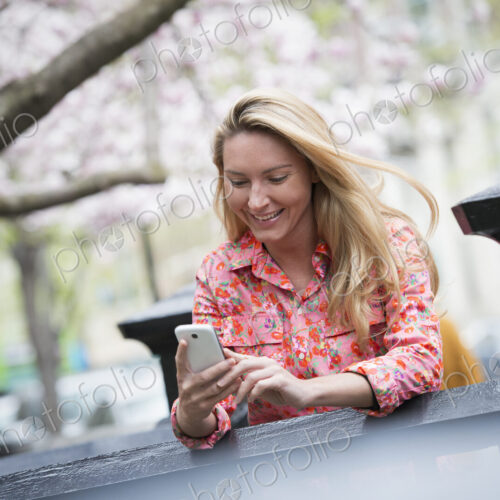 City life in spring. A young woman with long blonde hair sitting in a city park,…