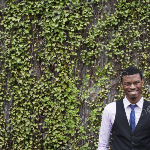 City life in spring. City park with a wall covered in climbing plants and ivy. A young…