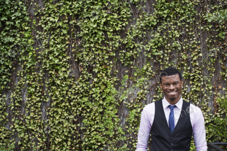 City life in spring. City park with a wall covered in climbing plants and ivy. A young…