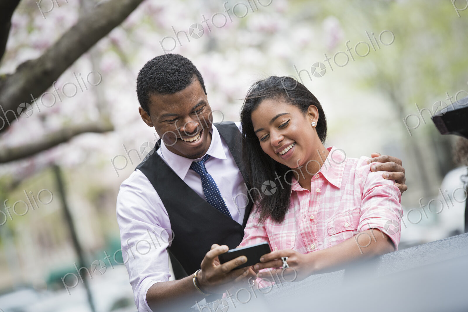 City life in spring. Young people outdoors in a city park. A couple side by side, with…