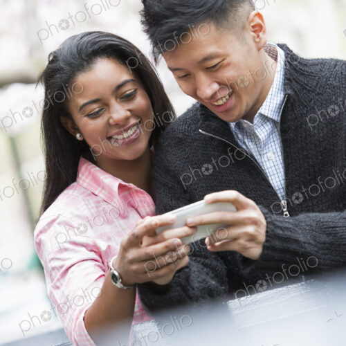 City life in spring. Young people outdoors in a city park. A couple side by side,…