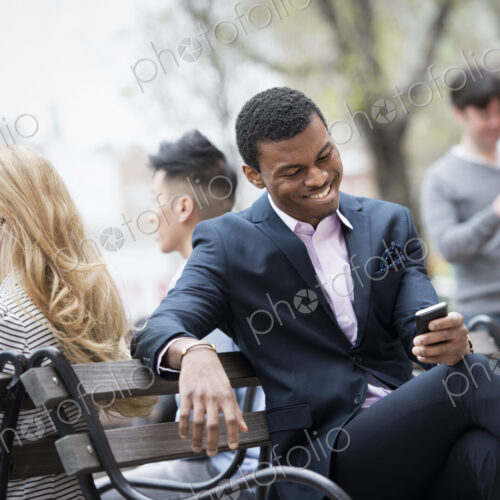 City life in spring. Young people outdoors in a city park. A group of men and women…