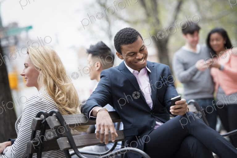 City life in spring. Young people outdoors in a city park. A group of men and women…