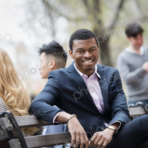 City life in spring. Young people outdoors in a city park. A group of men and women…