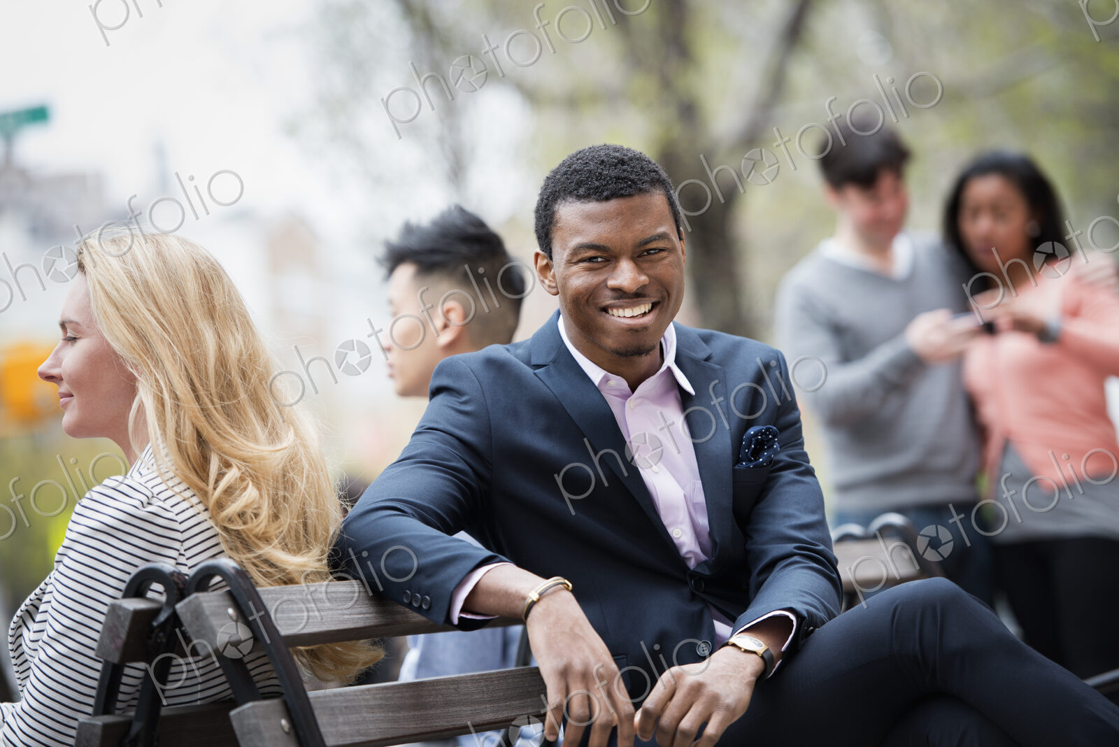 City life in spring. Young people outdoors in a city park. A group of men and women…