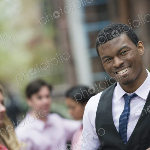 City life in spring. Young people outdoors in a city park. A man smiling at the…