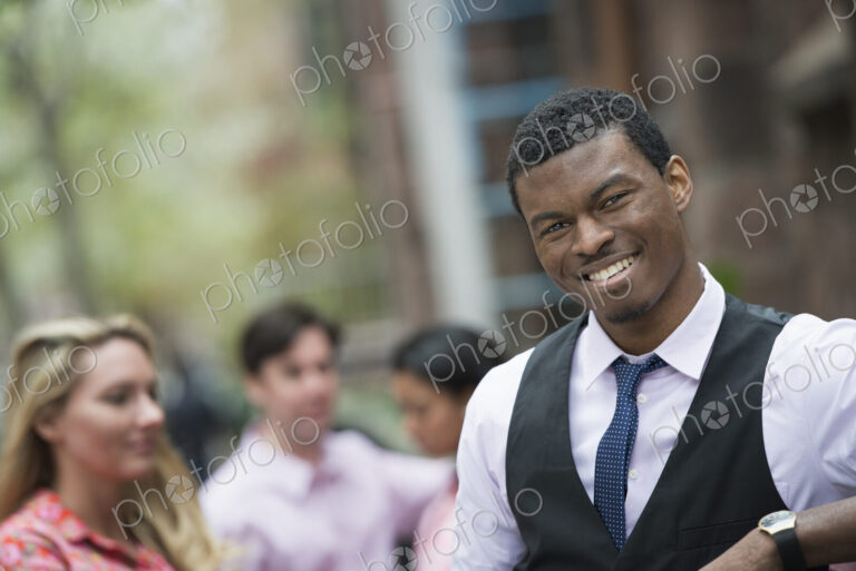 City life in spring. Young people outdoors in a city park. A man smiling at the…