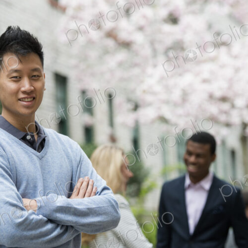City life in spring. Young people outdoors in a city park. A man with his arms folded… City life in spring. Young people outdoors in a city park. A man with his arms folded…
