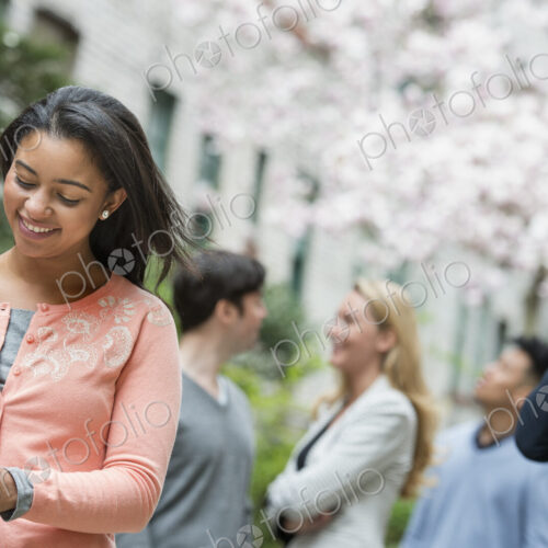 City life in spring. Young people outdoors in a city park. A woman in a pink shirt… City life in spring. Young people outdoors in a city park. A woman in a pink shirt…