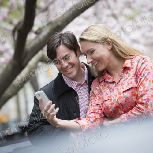 City life in spring. Young people outdoors in a city park. A young woman and man…