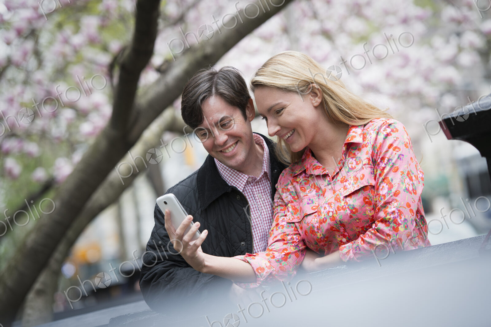 City life in spring. Young people outdoors in a city park. A young woman and man…