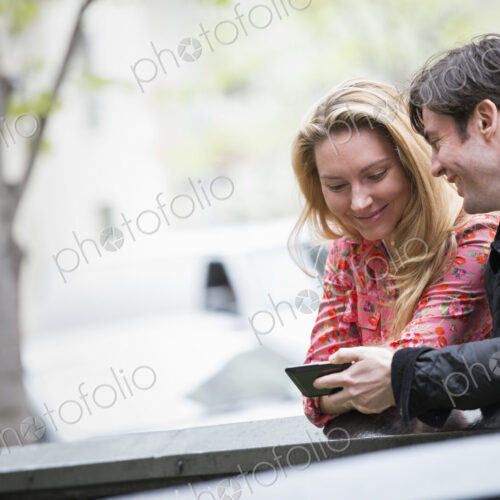 City life in spring. Young people outdoors in a city park. Two people sitting side by…