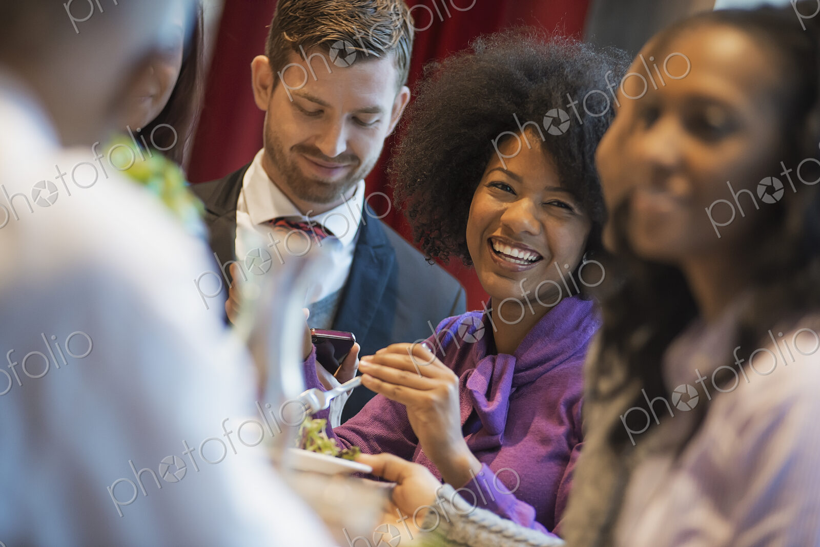 City life. A group of people in a coffee shop, one using a mobile phone, and others…