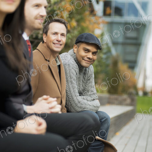 City life. A group of people on the go, keeping in contact, sitting on a bench. Men… City life. A group of people on the go, keeping in contact, sitting on a bench. Men…