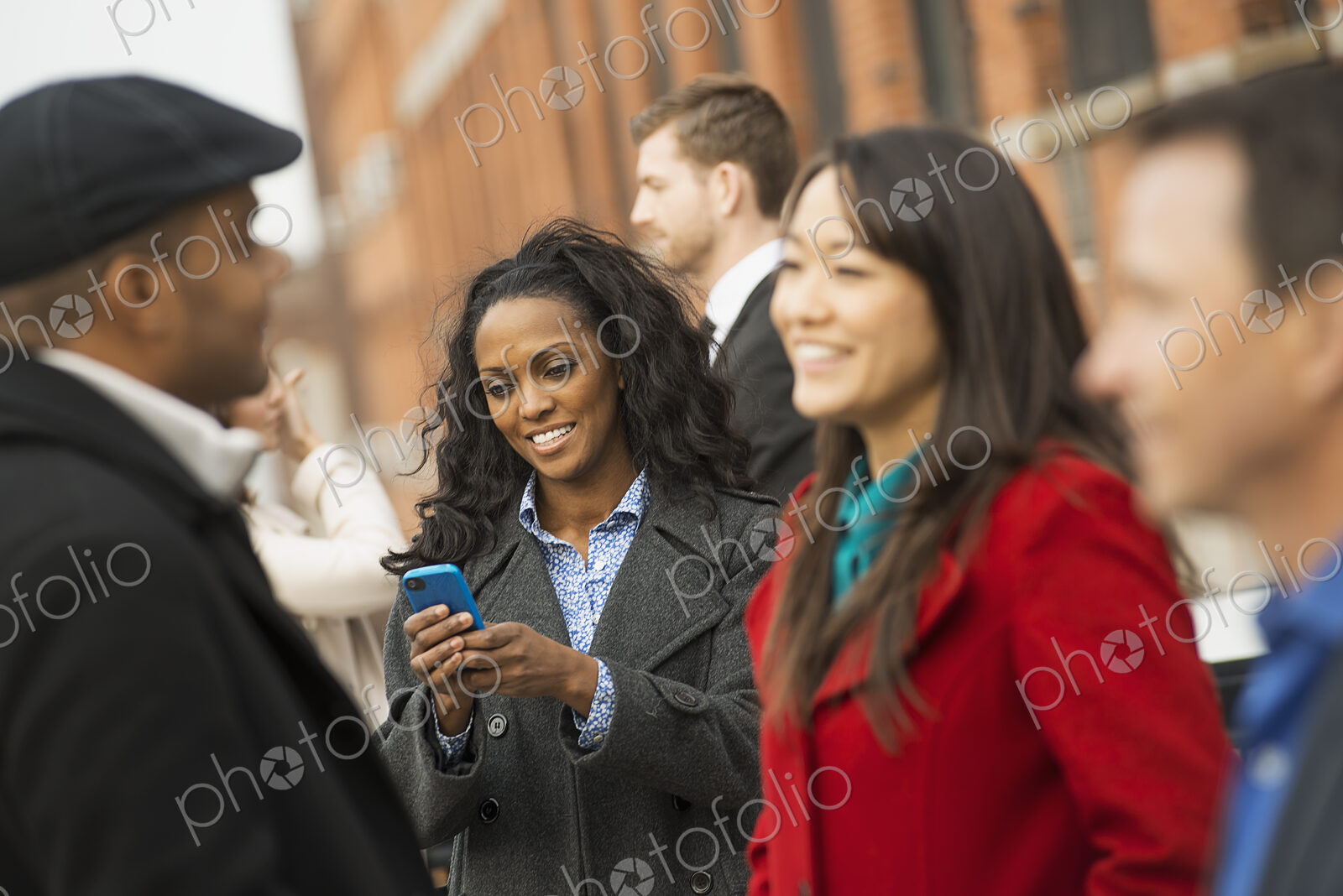 City life. A group of people on the go, keeping in contact, talking to each other. Men…