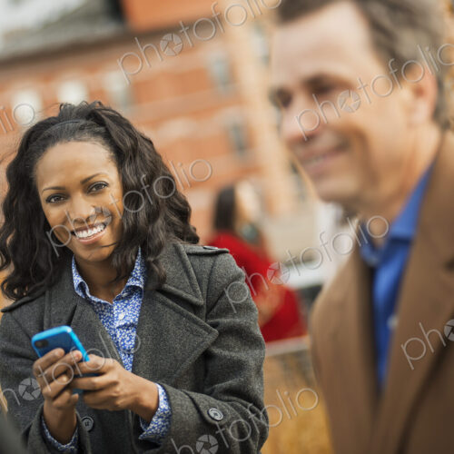 City life. A group of people on the go, keeping in contact, using mobile phones, and…