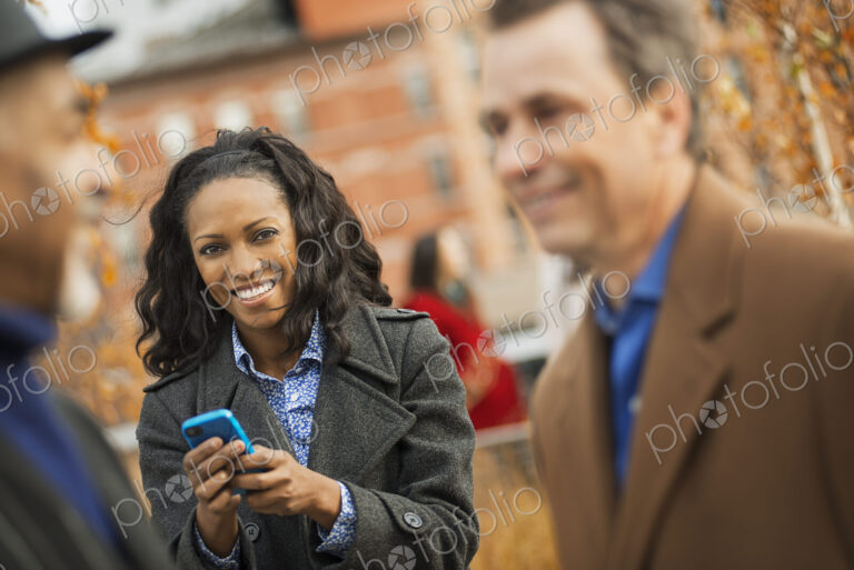 City life. A group of people on the go, keeping in contact, using mobile phones, and…