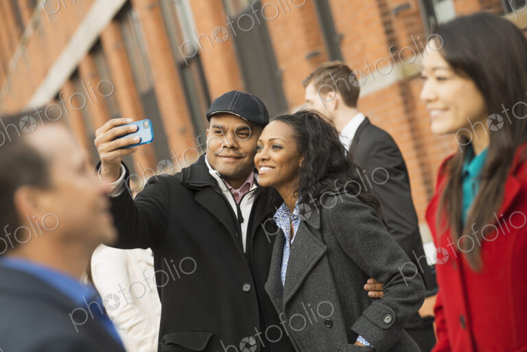City life. A group of people on the go, keeping in contact, using mobile phones, and…