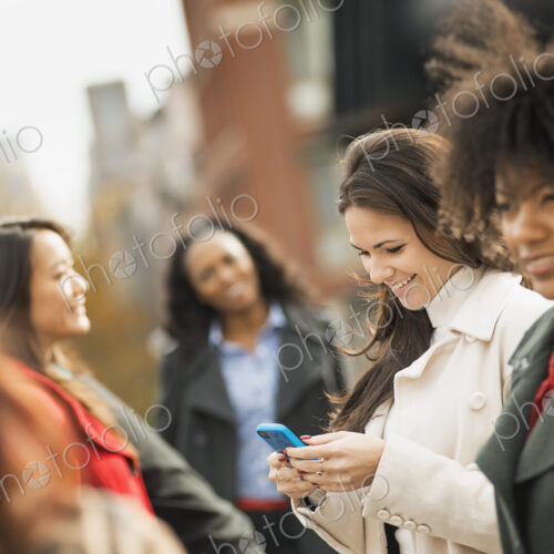 City life. A group of people on the go, keeping in contact, using mobile phones, and… City life. A group of people on the go, keeping in contact, using mobile phones, and…
