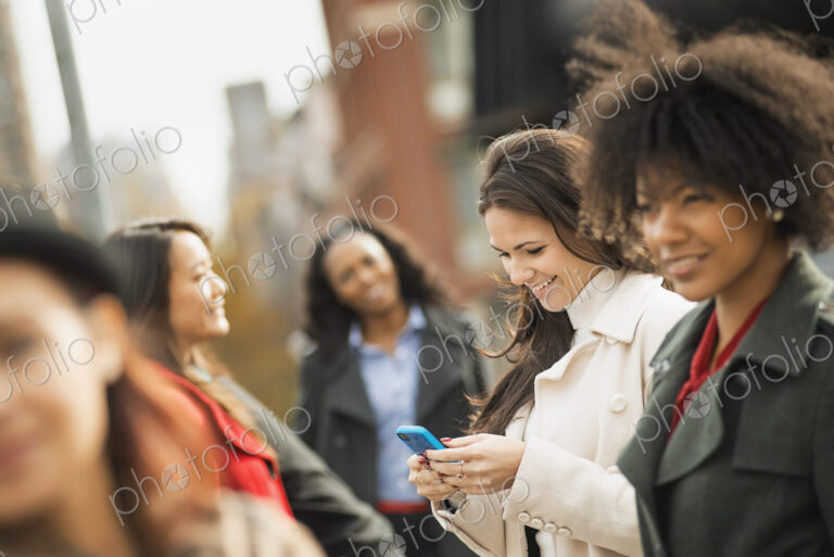City life. A group of people on the go, keeping in contact, using mobile phones, and…