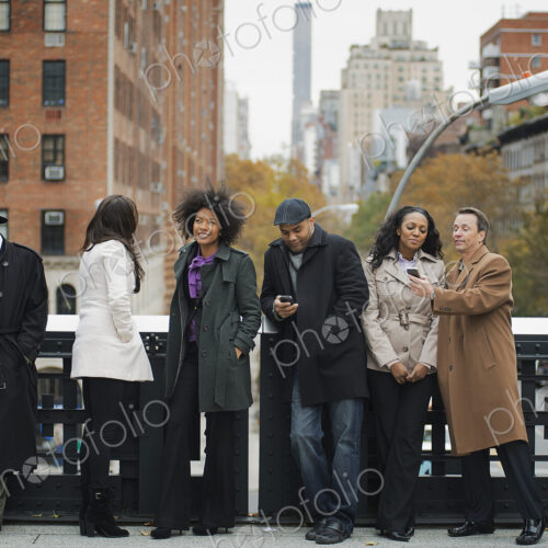 City life. A group of people on the go, keeping in contact, using mobile phones, and… City life. A group of people on the go, keeping in contact, using mobile phones, and…