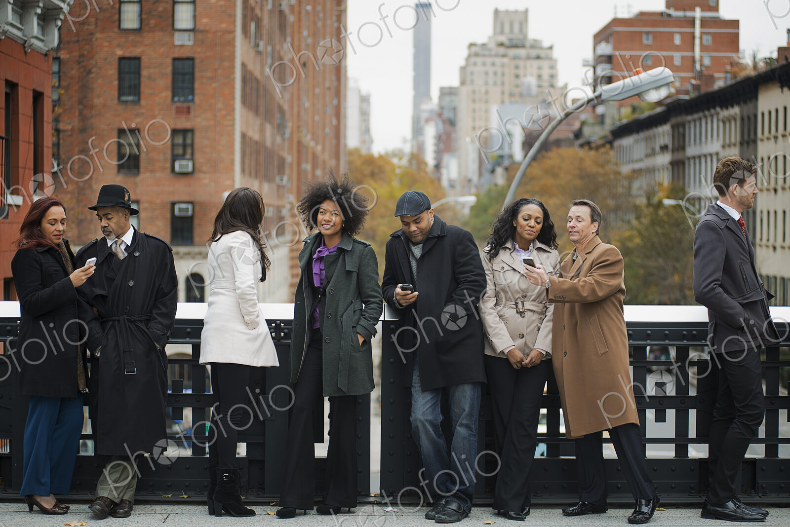 City life. A group of people on the go, keeping in contact, using mobile phones, and…