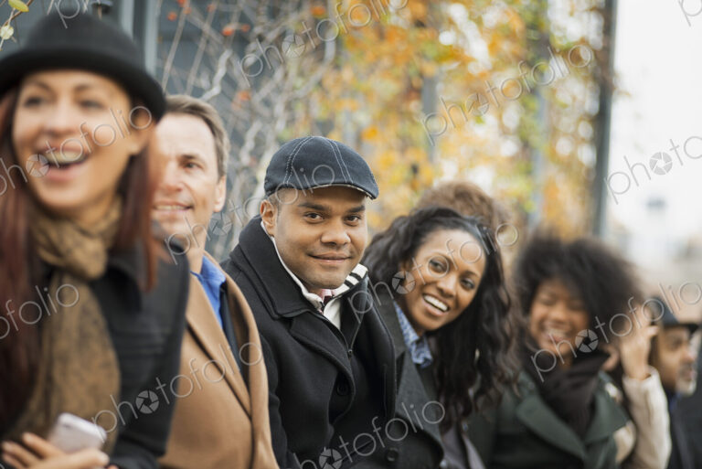City life. A group of people on the go, keeping in contact, using mobile phones. Men…