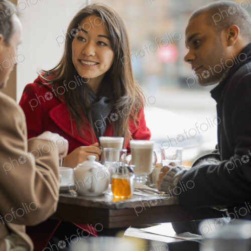 City life. A group of people on the go. Three people in a coffee shop sitting at a… City life. A group of people on the go. Three people in a coffee shop sitting at a…