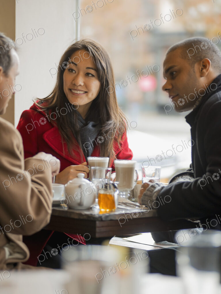 City life. A group of people on the go. Three people in a coffee shop sitting at a…