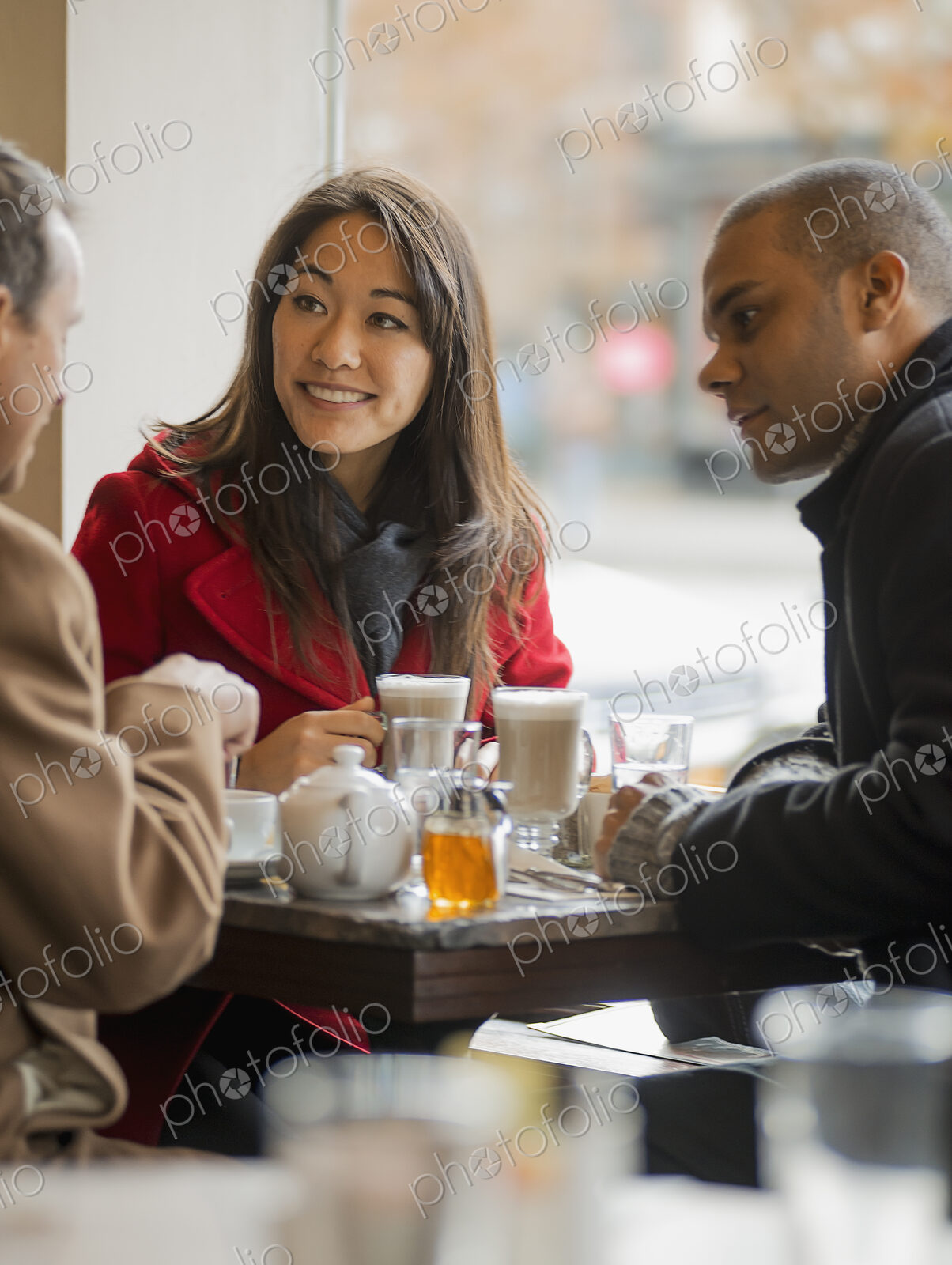City life. A group of people on the go. Three people in a coffee shop sitting at a…
