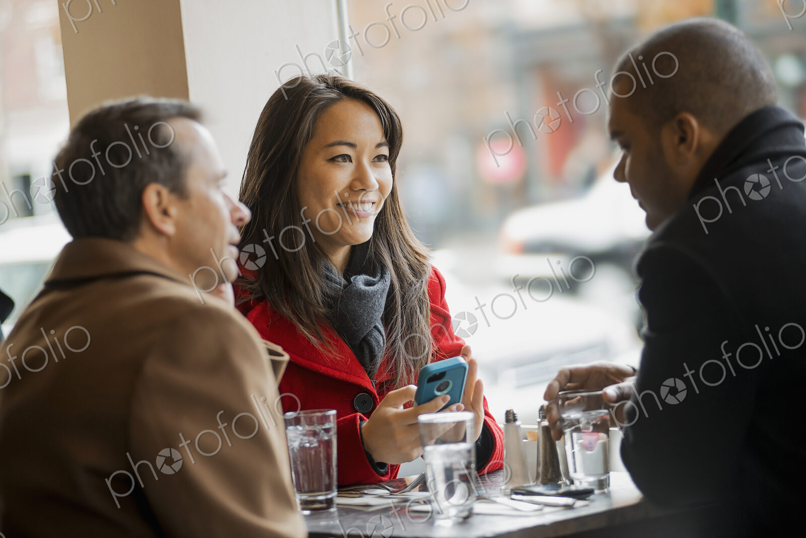 City life. A group of people on the go,using mobile phones, and talking to each other.…