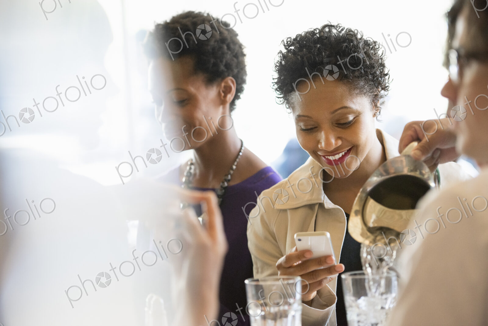 City life. A group of people sitting in a cafe or bar around a table. Men and women…