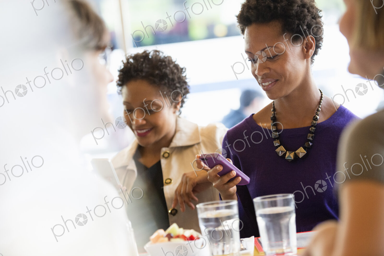 City life. A group of people sitting in a cafe or bar around a table. Men and women…