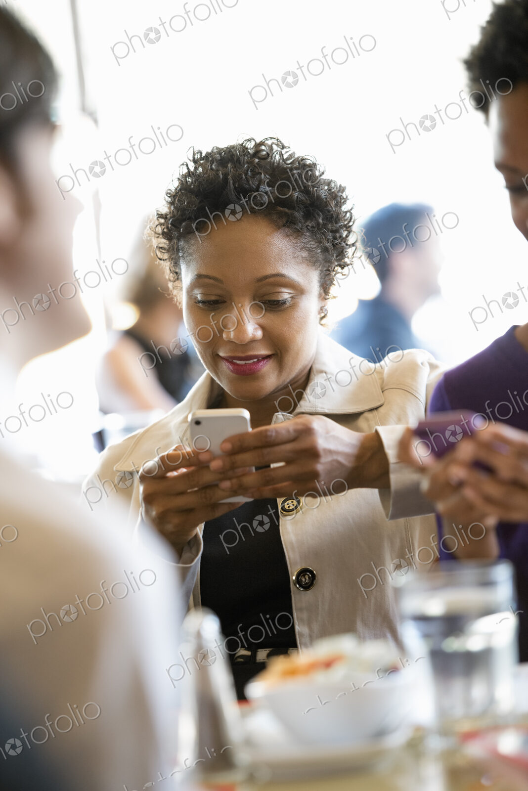 City life. A group of people sitting in a cafe or bar around a table. Men and women…