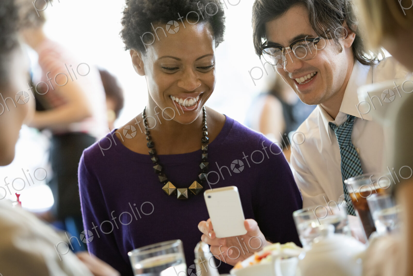 City life. A group of people sitting in a cafe or bar around a table. Men and women…