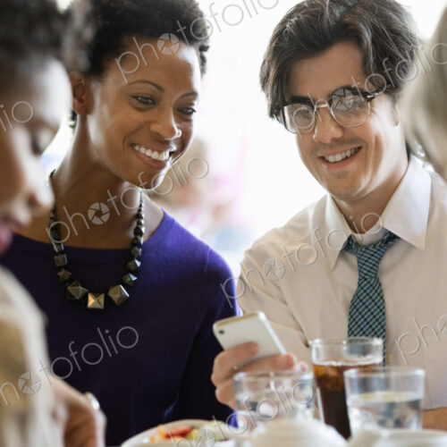 City life. A group of people sitting in a cafe or bar around a table. Men and women…