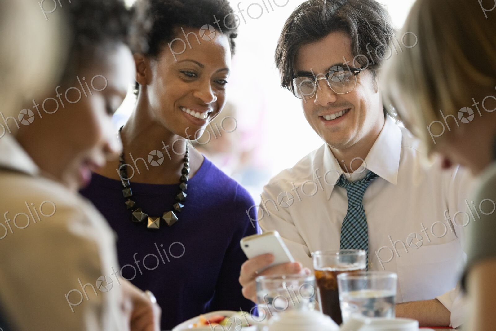 City life. A group of people sitting in a cafe or bar around a table. Men and women…