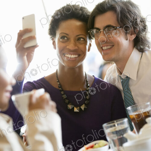 City life. A group of people sitting in a cafe or bar around a table. Men and women…