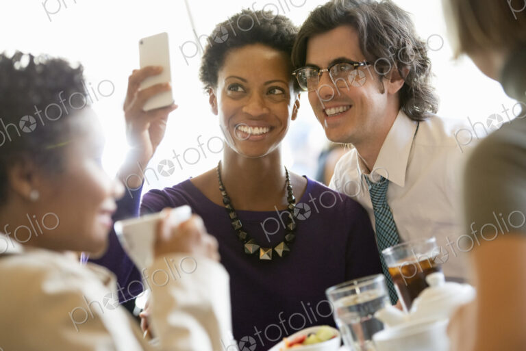 City life. A group of people sitting in a cafe or bar around a table. Men and women…