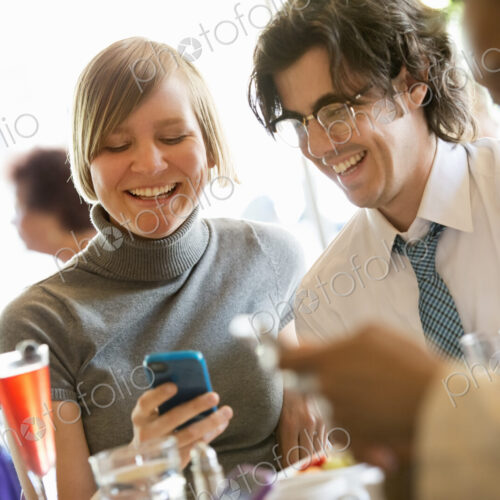 City life. A group of people sitting in a cafe or bar around a table. Men and women…