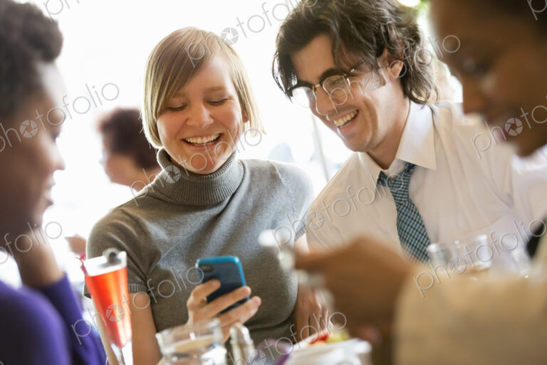 City life. A group of people sitting in a cafe or bar around a table. Men and women…