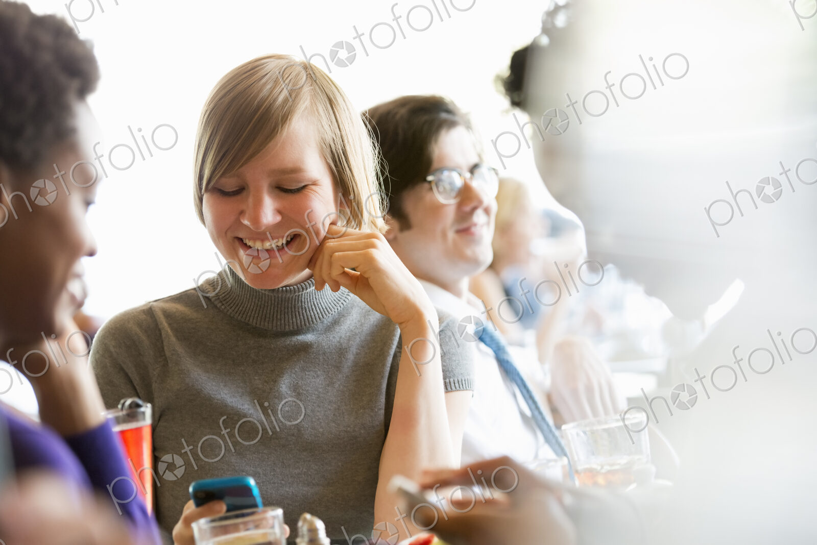 City life. A group of people sitting in a cafe or bar around a table. Men and women…