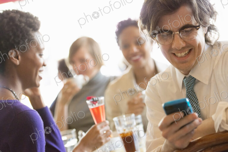 City life. A group of people sitting in a cafe or bar around a table. Men and women…