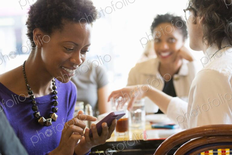 City life. A group of people sitting in a cafe or bar around a table. Men and women…
