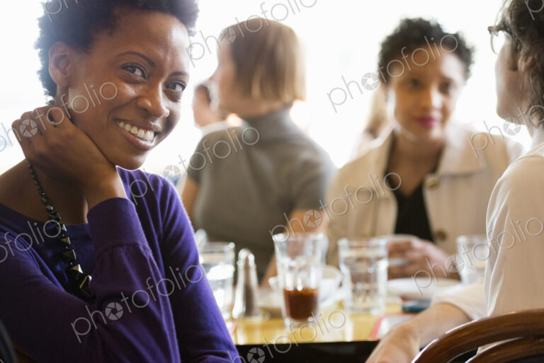 City life. A group of people sitting in a cafe or bar around a table. Men and women…