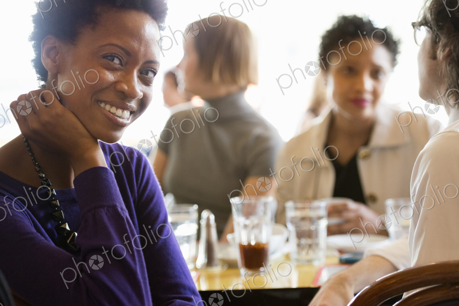 City life. A group of people sitting in a cafe or bar around a table. Men and women…